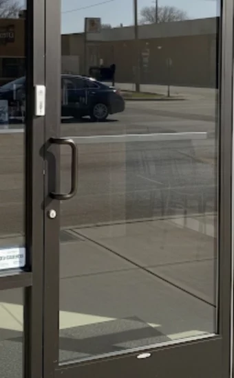 A secure, perfectly aligned commercial glass door on a Miami coffee shop after our emergency door repair service.
